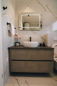 un baño con lavabo y espejo en Solis Apartments Bol 1, en Bol