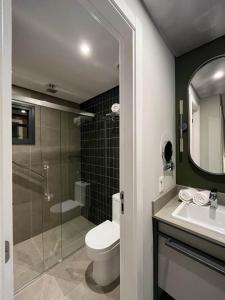 a bathroom with a toilet and a shower and a sink at Brava Mundo Hotel Boutique in Itajaí