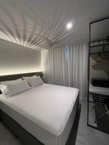 a bedroom with a white bed and a bunk bed at Brava Mundo Hotel Boutique in Itajaí