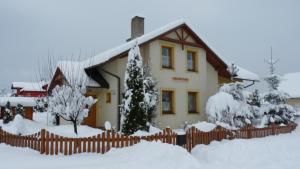 a house with a fence covered in snow at Privat INKA in Liptovský Mikuláš