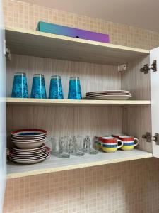 a shelf filled with plates and bowls and dishes at SIRA apartment 1 in Muscat