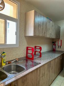 a kitchen with a sink and a red sign on the counter at SIRA apartment 1 in Muscat