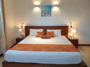 a bedroom with a large bed with orange pillows at Beachfront Apartment - Superb View in Pointe aux Biches +36 photos