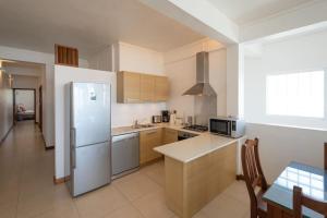 a kitchen with a refrigerator and a table in it at Beachfront Apartment - Superb View in Pointe aux Biches
