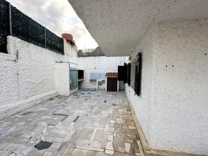 an empty hallway of a white building with a stone floor at Appartamento a 50 metri dalla spiaggia di Maladroxia c226 in Maladroscia