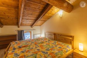 a bedroom with a bed in a room with wooden ceilings at Gîte Le Tsozal in Aussois