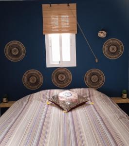 a bedroom with a bed with a blue wall and a window at Finca el Gaudi, casita Hendrika in L'Ampolla