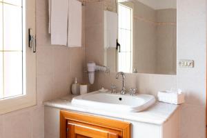 een badkamer met een wastafel en een spiegel bij Casa Duesse in Orosei +26 foto's