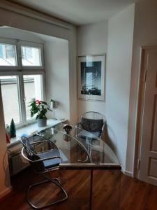 uma mesa de vidro e duas cadeiras num quarto em Alfred First em Regensburg