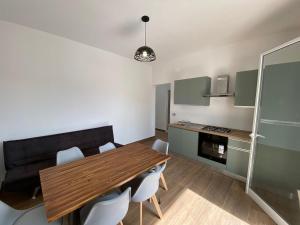 una cucina e una sala da pranzo con tavolo e sedie in legno di Residence Mariposa a Lido Conchiglia