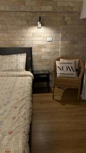 a bedroom with a bed and a chair and a table at דירת סטודיו באווירת צימר במתחם נגה,דקה הליכה מהים. in Tel Aviv