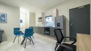 a kitchen with blue chairs and a table at Chic Modern Midrand Escape in Midrand