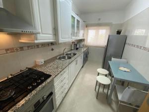 a small kitchen with a sink and a stove at APARTAMENTO VISTA MAR in Lourinhã