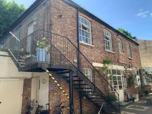 a staircase on the side of a brick building at Bright and peaceful mews flat in London