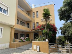 a building with flowers in front of it at APARTAMENTO VISTA MAR in Lourinhã