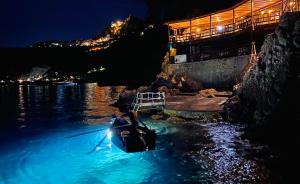 a person in a boat in the water at night at UNA HOTELS Capotaormina in Taormina