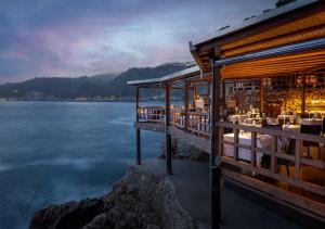 a restaurant on the shore of a body of water at UNA HOTELS Capotaormina in Taormina