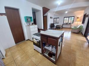Casa Juçara Paraty في باراتي: مطبخ مع موقد وغرفة معيشة