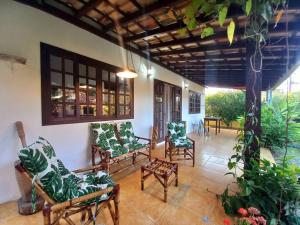 Casa Juçara Paraty في باراتي: شرفة مع كراسي وطاولة وبعض النباتات