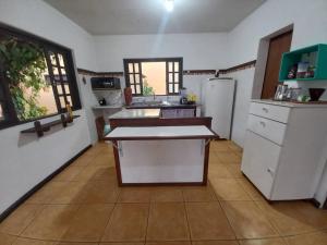 Casa Juçara Paraty في باراتي: مطبخ فيه ثلاجة وطاولة