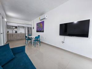 sala de estar con sofá y TV en la pared en Centrally located Villa with 3 Pools -Food & Beach walking distance, en Arecibo