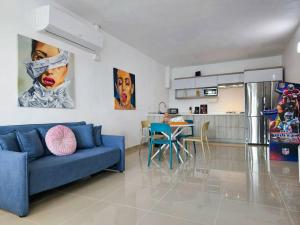 ein Wohnzimmer mit einem blauen Sofa und einer Küche in der Unterkunft Centrally located Villa with 3 Pools -Food & Beach walking distance in Arecibo