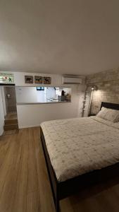 a bedroom with a large bed and a kitchen at דירת סטודיו באווירת צימר במתחם נגה,דקה הליכה מהים. in Tel Aviv