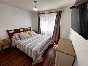 a small bedroom with a bed and a window at Casa en San Pedro de la Paz, 5 personas, 2 dormitorios, gimnasio in San Pedro de la Paz