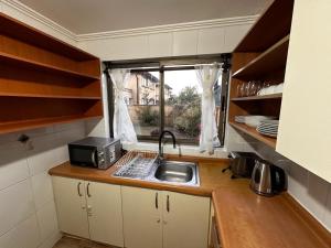 una pequeña cocina con fregadero y ventana en Casa en San Pedro de la Paz, 5 personas, 2 dormitorios, gimnasio, en San Pedro de la Paz