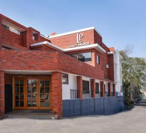 budynek z czerwonej cegły z napisem w obiekcie Hotel Lalit Palace w mieście Dehradun