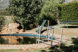 a pool of water with a table and a picnic table at Mont Rouge Cottage in Tulbagh