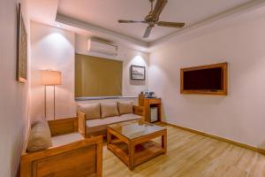 a living room with a couch and a tv at Hotel Lalit Palace in Dehradun