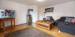 ein Wohnzimmer mit einem Sofa und einem Holzofen in der Unterkunft Gästehaus Alpenhorst in Oberstdorf