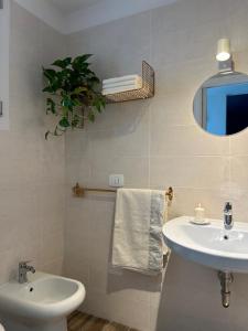 a white bathroom with a sink and a mirror at B&B IL CEDRO in Reggiolo