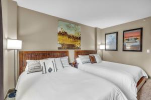 two beds sitting next to each other in a bedroom at Modern 2BR Condo Near Ski Lift Walk Everywhere in Park City