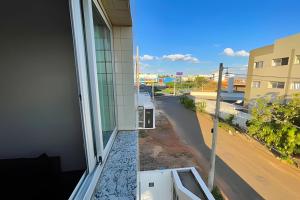 uma vista para a rua a partir de uma varanda de um edifício em 207- APARTAMENTO de 2 QUARTOS no ALTO CAIÇARAS em Patos de Minas