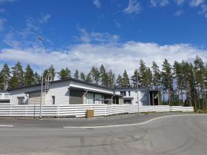 une maison avec une clôture blanche en face d'une route dans l'établissement Kaksio Kuopion Saaristokaupungissa, à Kuopio