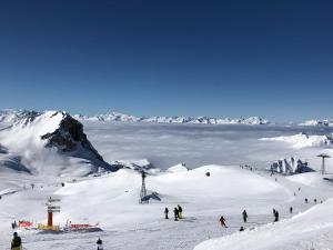 a group of people skiing down a snow covered mountain at Studio 28m2 vue pistes plein sud du dimanche au dimanche in La Plagne