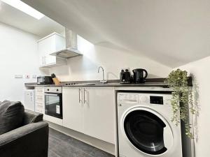 a kitchen with a washing machine and a sink at Cosy, Charming 2-Bedroom Oasis in Ilkeston