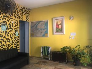 uma sala de estar com um sofá e uma parede amarela em Onça da Praia Hostel em Vitória
