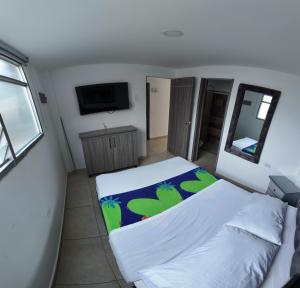 a small bedroom with a bed and a mirror at Hotel Plaza Paris in Calarcá