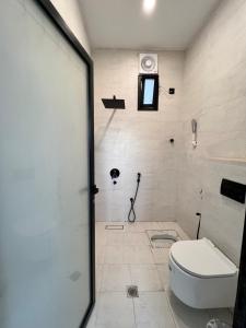 a white bathroom with a toilet and a shower at استراحة غزل in Medina