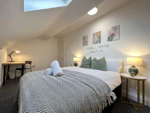 a bedroom with a bed and two tables with lamps at Cosy, Charming 2-Bedroom Oasis in Ilkeston