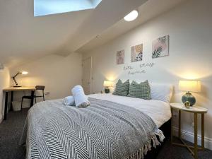 a bedroom with a bed and two tables with lamps at Charming 2-Bedroom Oasis in Ilkeston