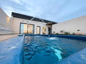 a swimming pool in front of a house with water at استراحة غزل in Medina