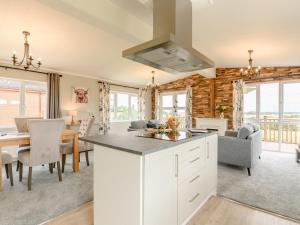 a kitchen and dining room with white cabinets and a table at 2 Bed in Kinlet 92659 in Kinlet