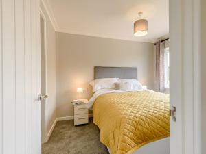 a bedroom with a bed with a yellow bedspread at 2 Bed in Kinlet 92659 in Kinlet