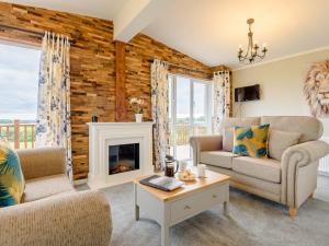 a living room with two chairs and a fireplace at 2 Bed in Kinlet 92657 in Kinlet