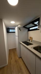 a kitchen with a white refrigerator and a sink at דירת סטודיו באווירת צימר במתחם נגה,דקה הליכה מהים. in Tel Aviv