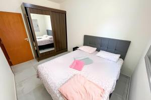 um quarto com uma cama com toalhas cor-de-rosa em 103 - Apartamento Completo Para Até 5 Hóspedes em Patos de Minas
